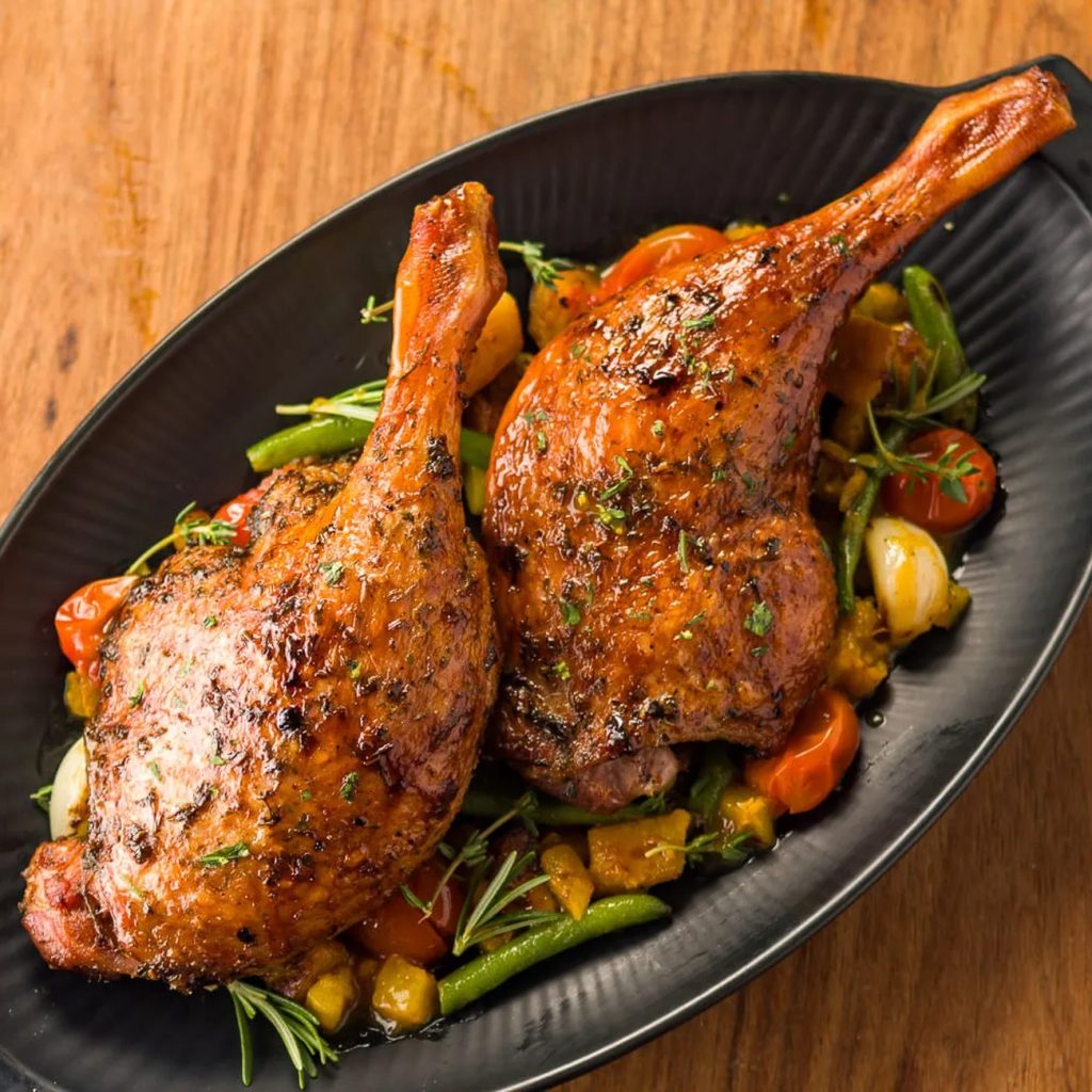 Receita de Coxa e sobrecoxa de pato assada com legumes ao molho de laranja