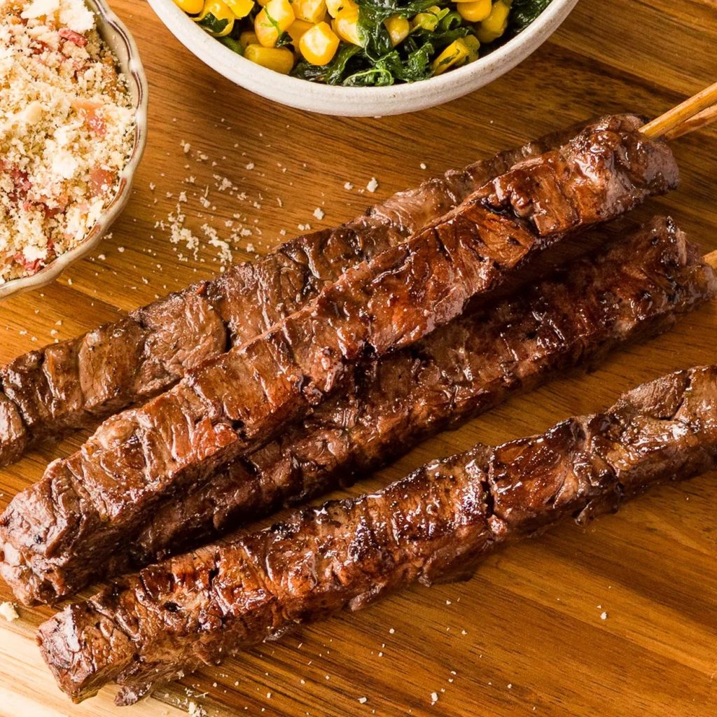 Receita de Espetinho bovino com salada de milho com espinafre e vinagrete de cebola